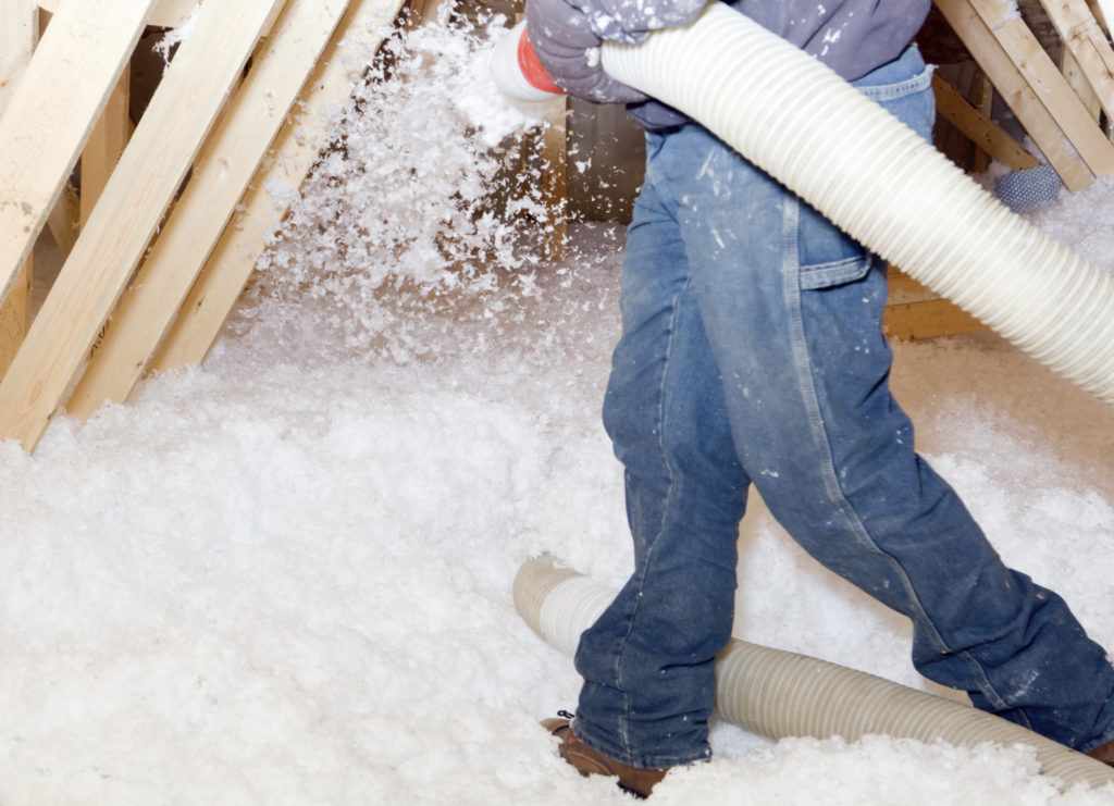 Insulation being sprayed into an attic