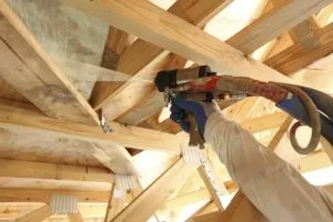 Spray foam insulation being applied in an unfinished building.